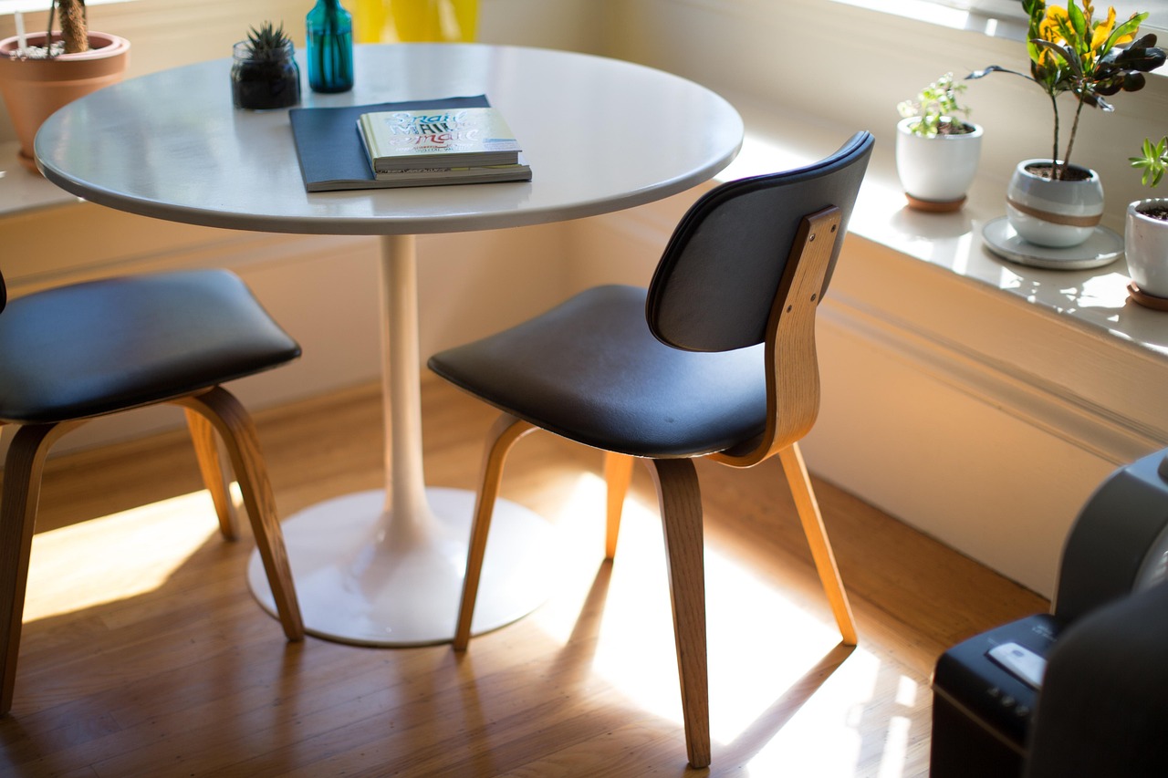 A bright room with a table, chairs and indoor plants